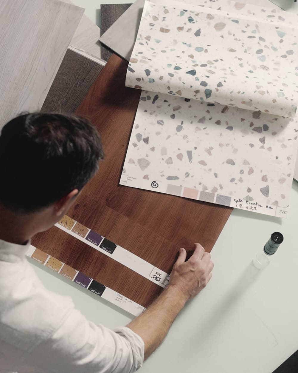 Дизайнер напольных покрытий Moduleo за работой, склонившись над новым рисунком деревянного пола